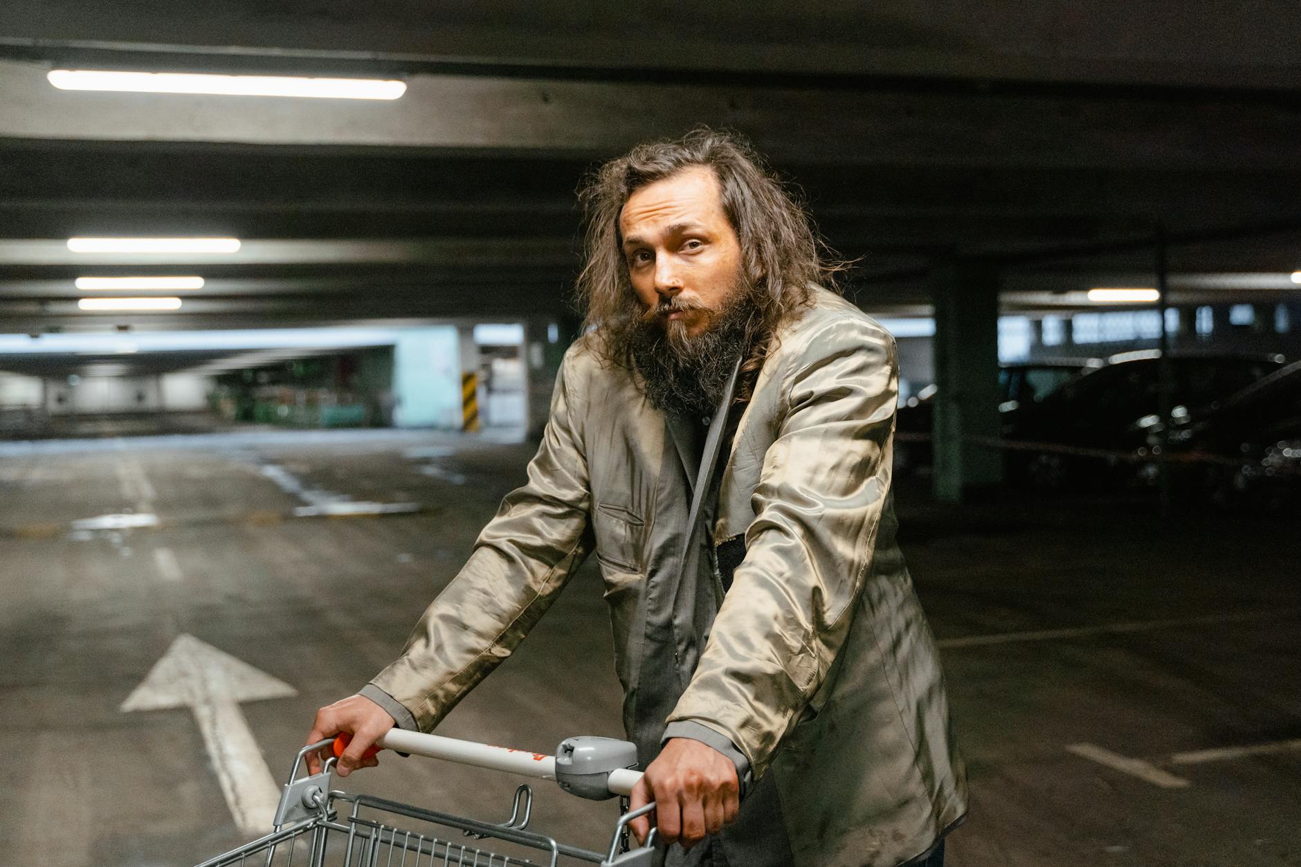 man in gray coat holding a shopping cart