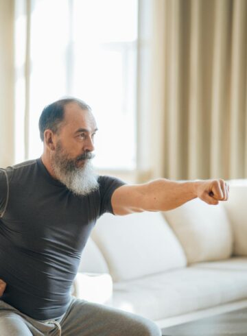 a man in black crew neck t shirt and gray pants doing an exercise