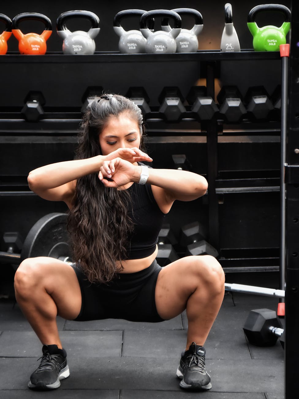 a woman in black sportswear working out in the gym