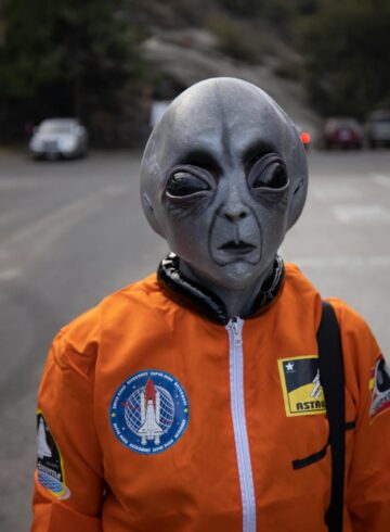 alien in astronaut suit on city street
