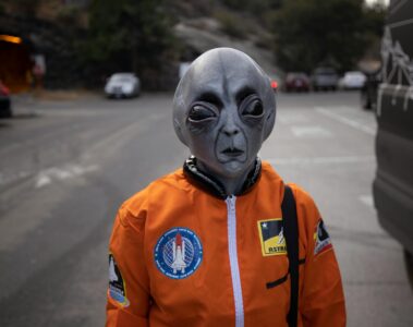alien in astronaut suit on city street