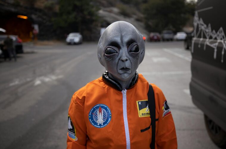 alien in astronaut suit on city street