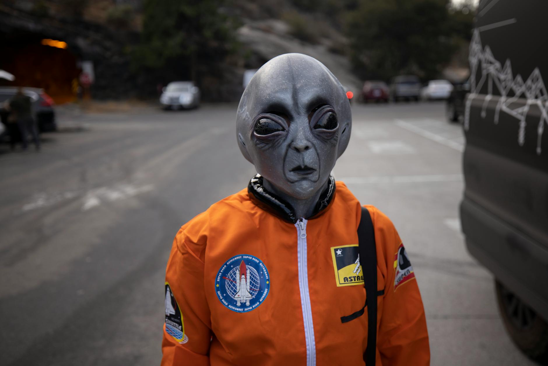 alien in astronaut suit on city street