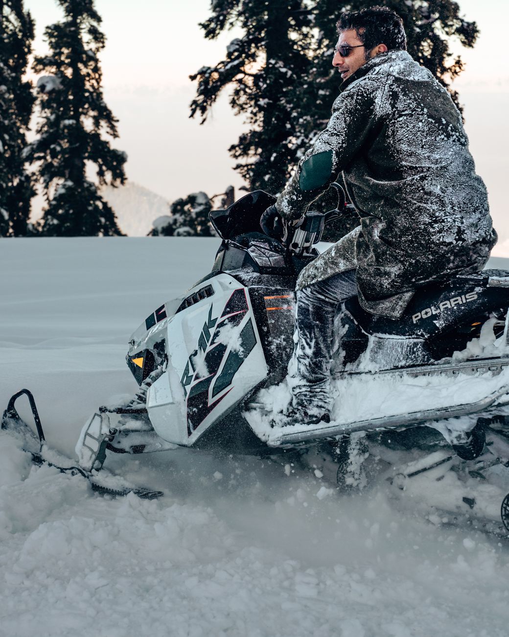 a man riding white and black snow mobile